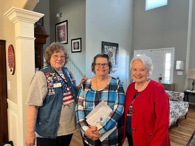 Three women are standing next to each other. the middle woman is holding her DAR membership certificate. She was just installed as a new member of our chapter and of DAR.